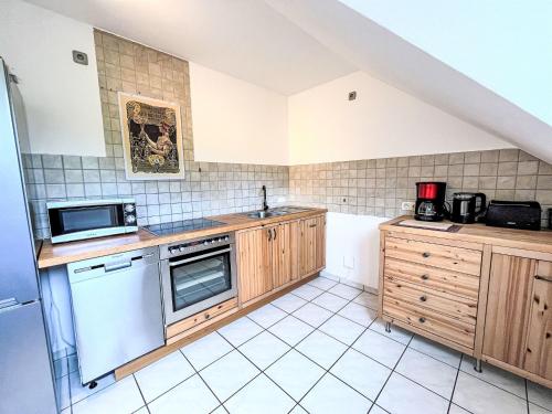 a kitchen with wooden cabinets and white appliances at Apartment Ferienapartments Adenau-4 by Interhome in Adenau