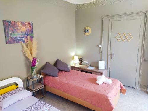 ein Schlafzimmer mit einem rosa Bett und einem Tisch in der Unterkunft Anastasia apartment in Kalamata