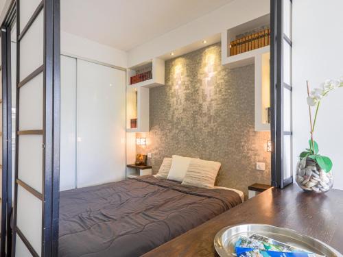 a small bedroom with a bed and a table at Apartment Saint Christophe by Interhome in Nice