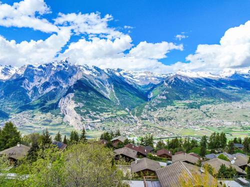 uitzicht op een stad met bergen op de achtergrond bij Chalet La Truffe by Interhome in Nendaz