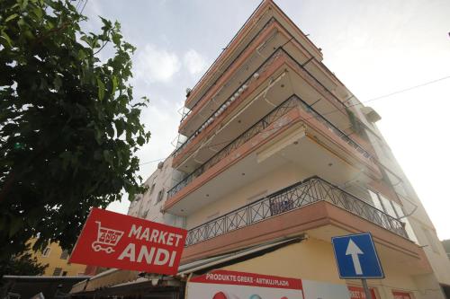 a building with a market and a sign in front of it at Viron Apartament in Himare