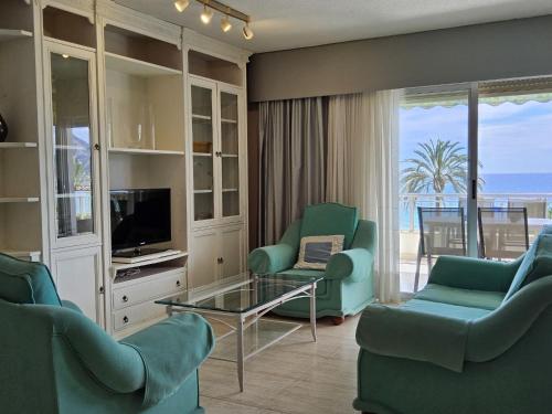 sala de estar con sillas, TV y balcón en Apartment Marysol by Interhome, en Altea