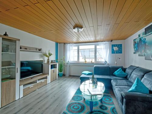 uma sala de estar com um sofá azul e uma mesa em Holiday Home Ferienhaus Born by Interhome em Schieder-Schwalenberg