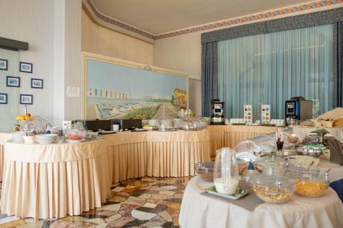 un restaurante con dos mesas con comida. en Hotel Vela D'oro ***S en Bardolino