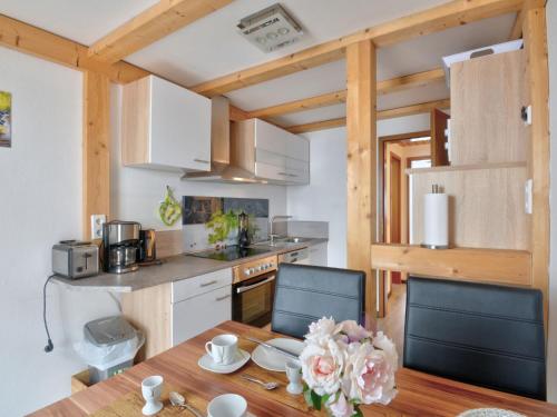 a kitchen with a wooden table and chairs and a kitchen with a counter at Holiday Home Ferienhaus Born by Interhome in Schieder-Schwalenberg