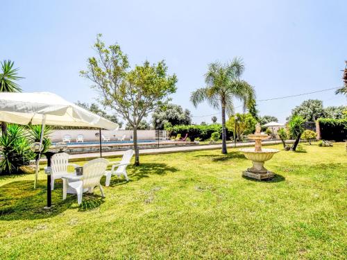 a park with chairs and a fountain in the grass at Apartment White Pool by Interhome in Siracusa