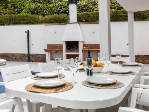 リョレート・デ・マルにあるVilla Palmbeach by Interhomeの白いテーブル(白い椅子付)とワイングラス