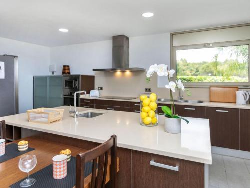 a kitchen with a large white counter with a vase of flowers at Villa Palmbeach by Interhome in Lloret de Mar