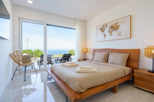 a bedroom with a large bed and large windows at Axess Villa with panoramic ocean view in Lourinhã