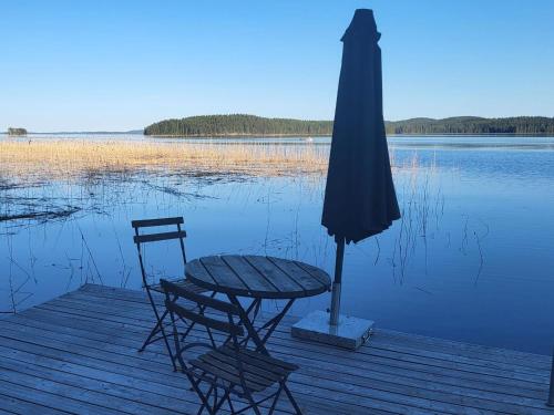 a table and two chairs and an umbrella on a dock at Holiday Home Willa klaara by Interhome in Patajoki