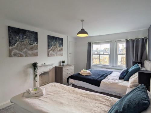 1 dormitorio con 2 camas y chimenea en Spacious Georgian 3bedroom Apartment, 5 mins from Bath Abbey, en Bath