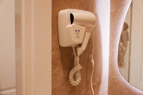 a phone hanging on a wall next to a curtain at Kruja Townscape Rooms in Krujë