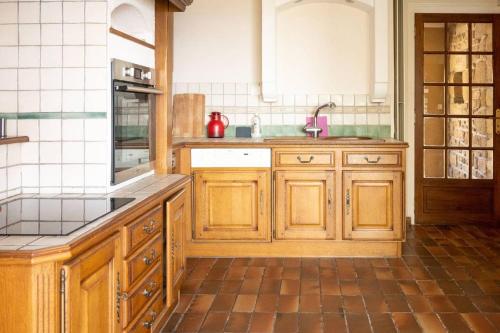 a kitchen with wooden cabinets and a sink at villa port l epine, 4 chambres, vue mer in Trélévern