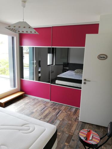 - une chambre avec des armoires rouges et blanches et un lit dans l'établissement coin de paradis 3 chambres, à Fouras