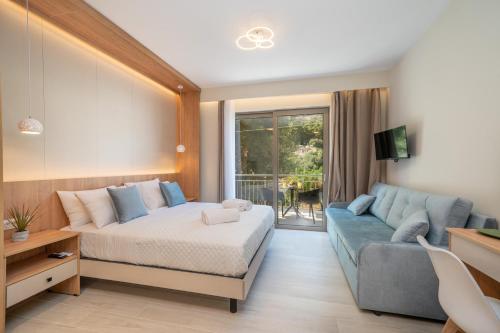 a bedroom with a bed and a blue couch at Nicole Studios in Ayia Evfimia