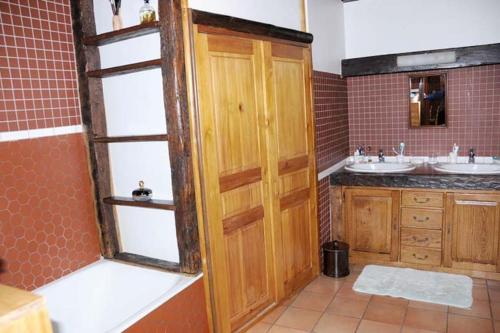 La salle de bains est pourvue de 2 lavabos et d'une porte en bois. dans l'établissement Villa Caroly, à Léguillac-de-Lauche