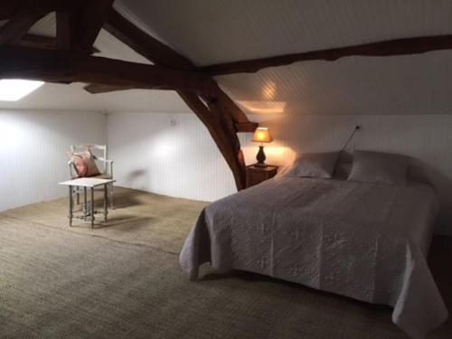 une chambre avec un lit et une table avec une lampe dans l'établissement Villa Caroly, à Léguillac-de-Lauche