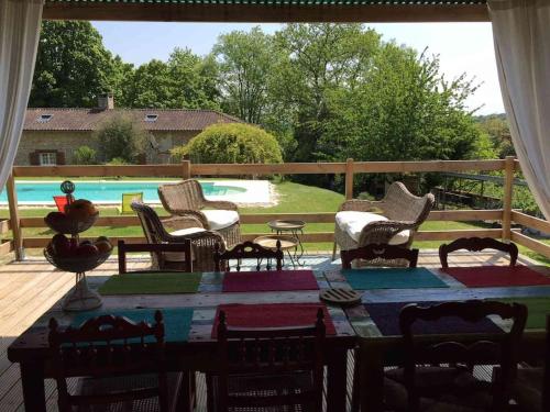 un patio avec une table et des chaises et une piscine dans l'établissement Villa Caroly, à Léguillac-de-Lauche