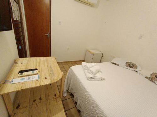 a small room with a bed and a table at Pousada Tô na Praia! - 1ª Filial da Tô em Casa em Cabo Branco in João Pessoa
