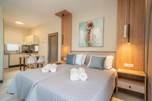 a bedroom with a large bed with towels on it at Nicole Studios in Ayia Evfimia
