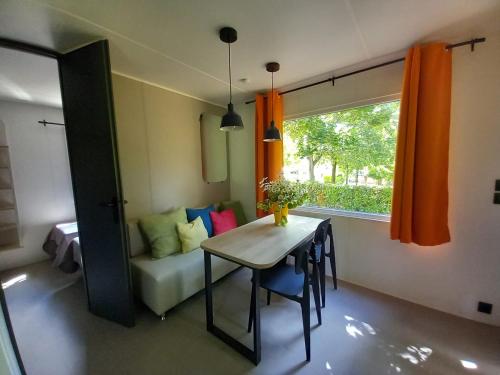 a room with a table and a couch and a window at Camping Villaggio Il Collaccio in Preci