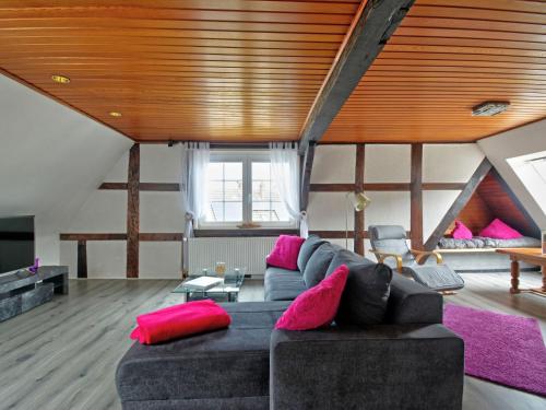 a living room with a black couch and pink pillows at Apartment Born 3 by Interhome in Schieder-Schwalenberg