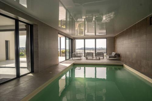 une maison avec une piscine dans une chambre dans l'établissement agapanthes, Facing the sea, indoor pool, à Pleumeur-Bodou