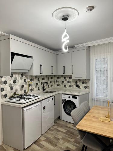 a kitchen with white cabinets and a table and a stove at Öztürk VIP in Pelitli