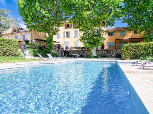une piscine avec deux chaises et un bâtiment dans l'établissement Holiday Home Le Bastidon by Interhome, à Besse-sur-Issole