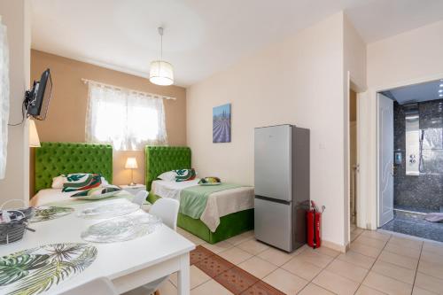 a small room with two beds and a refrigerator at Family Inn Apartments&suites in Neos Marmaras