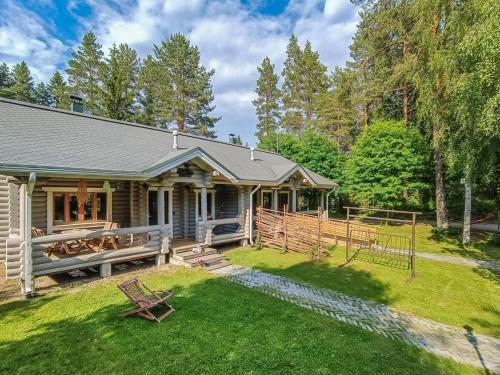 une maison en rondins avec une clôture et une cour dans l'établissement Holiday Home Purnutar a by Interhome, à Kolinkylä