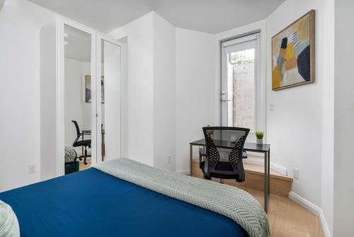 a bedroom with a bed and a table and a chair at Spacious 3BDR Sleeps 6 with Patio By Little Italy! in Toronto