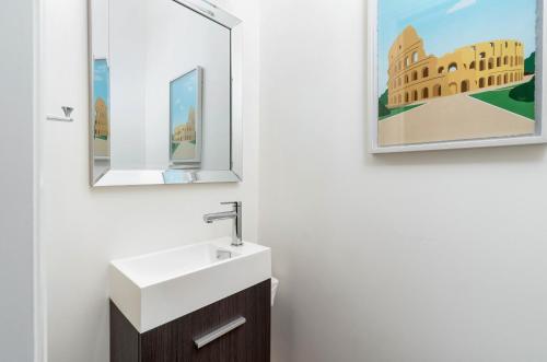 a bathroom with a sink and a mirror at Spacious 3BDR Sleeps 6 with Patio By Little Italy! in Toronto