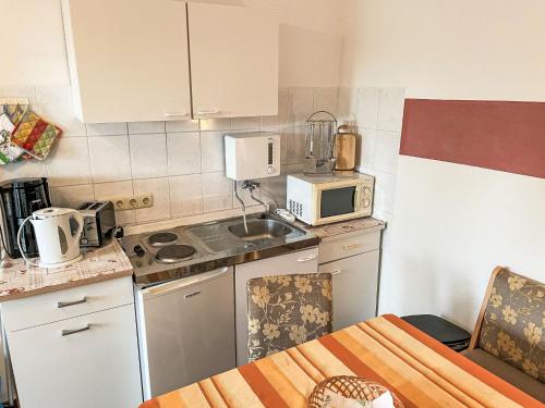 una piccola cucina con lavandino e forno a microonde di Apartment Schmidt App- 3 by Interhome a Zinnowitz