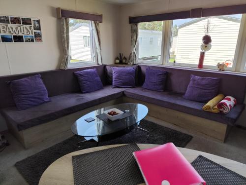 a living room with a blue couch and purple pillows at G & M Static Caravan Edinburgh in Port Seton