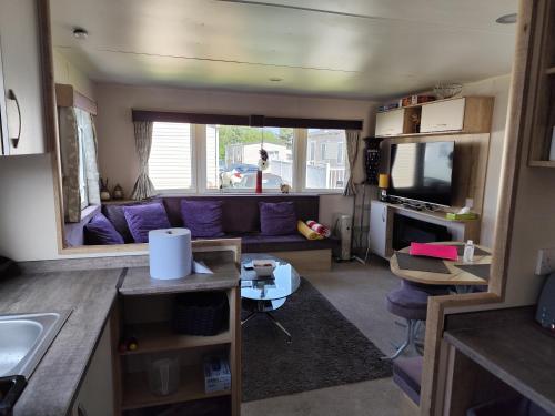 a living room with a purple couch in a caravan at G & M Static Caravan Edinburgh in Port Seton