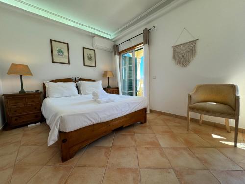 a bedroom with a bed and a chair and a window at Happy Silva Guesthouse in Lagos