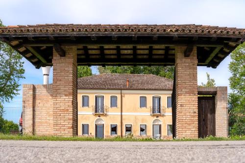 a large brick building with a building behind it at Barchessa Cappelletto in Torre di Mosto