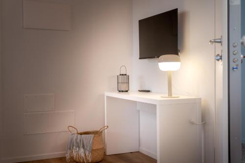 a white room with a table with a lamp on it at Barchessa Cappelletto in Torre di Mosto