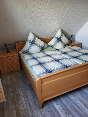 a bed with two pillows on it in a room at Am Storchennest in Ahrenshagen