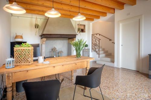 a dining room with a table and chairs and a fireplace at Barchessa Cappelletto in Torre di Mosto