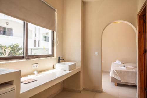 a bathroom with a sink and a window at Atma Beach Rooms & Suites in Faliraki