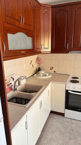 a kitchen with wooden cabinets and a sink at Proluxe Apartments in Alexandroupoli