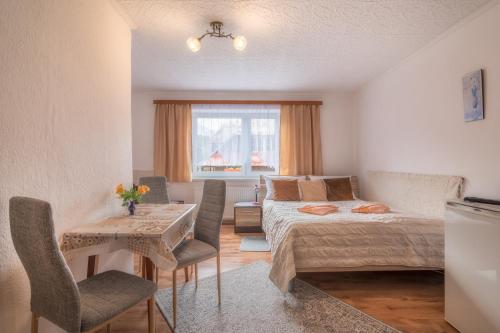 Schlafzimmer mit einem Bett, einem Tisch und Stühlen in der Unterkunft Privát Marika in Ždiar