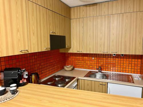 a kitchen with wooden cabinets and a sink and a stove at Golden Corner Oldtown Luzern in Luzern