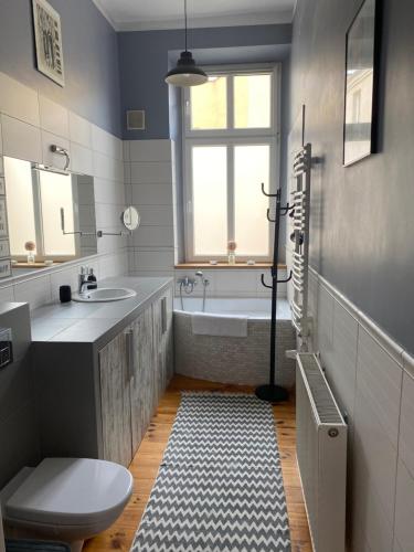 a bathroom with a tub and a toilet and a sink at Apartament Kamienica Centrum in Kętrzyn