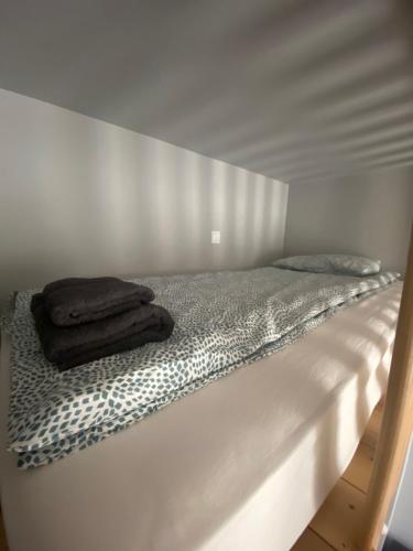 a white bed with a wooden frame with two towels on it at Apartament Kamienica Centrum in Kętrzyn