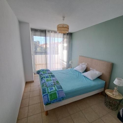 une chambre avec un lit et une fenêtre dans une pièce dans l'établissement LES EMBRUNS - SPACIEUX APPARTEMENT AVEC PISCINE - wifi- parking, à Saint-Cyprien