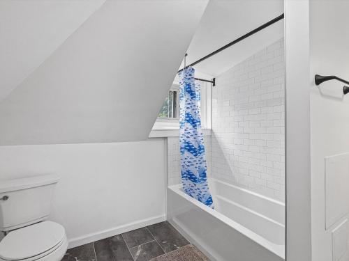a white bathroom with a toilet and a window at Shadyside, Central 3C Spacious & Modern Private Bedroom With Shared Bathroom and Free Parking in Pittsburgh