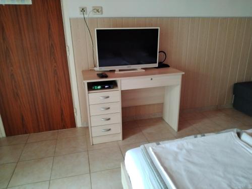 a room with a tv on a desk with a bed at Apartmani Marijan in Crikvenica